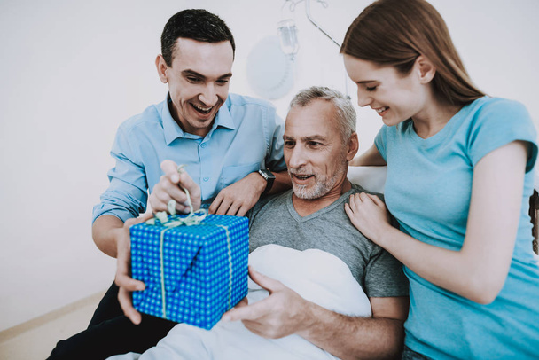 Old Man and Family in White Room. Patient and Family Smile and Happy. Rehabilitation in Clinic. Rehabilitation in Hospital. Diagnosis Good in Clinic. White Room and Old Patient. Family in Clinic. - Φωτογραφία, εικόνα