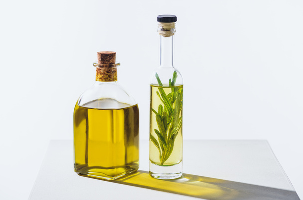 two bottles of natural herbal essential yellow oils on white cube - 写真・画像