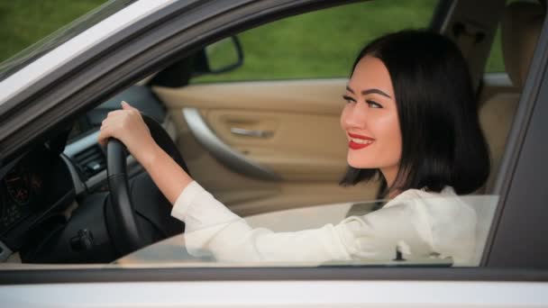 Retrato de una mujer bonita y feliz coqueteando con una cámara sentada en el coche. Hablando con otro conductor en un atasco de tráfico
. - Imágenes, Vídeo