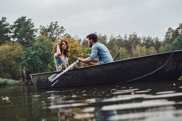 beautiful couple enjoying romantic date while rowing a boat - Photo, Image