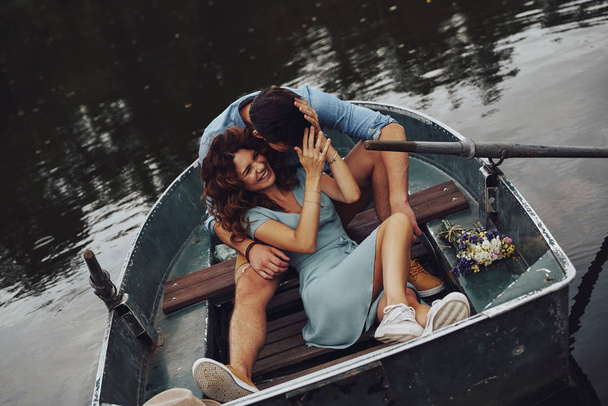 laughing caucasian young couple embracing while enjoying romantic date on lake - Foto, Imagen