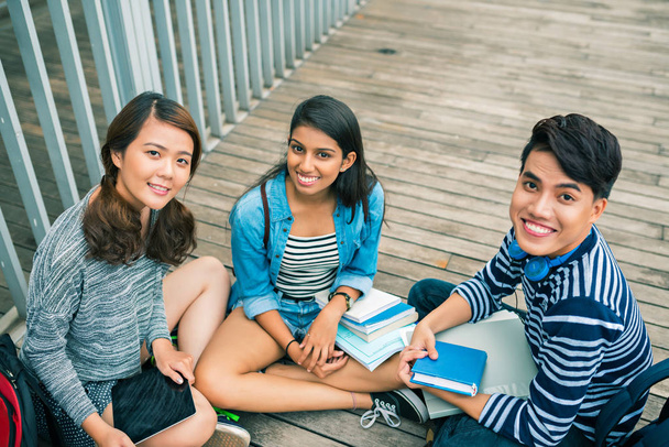 Feliz multi-étnicos estudiantes universitarios con libros mirando a la cámara
 - Foto, Imagen