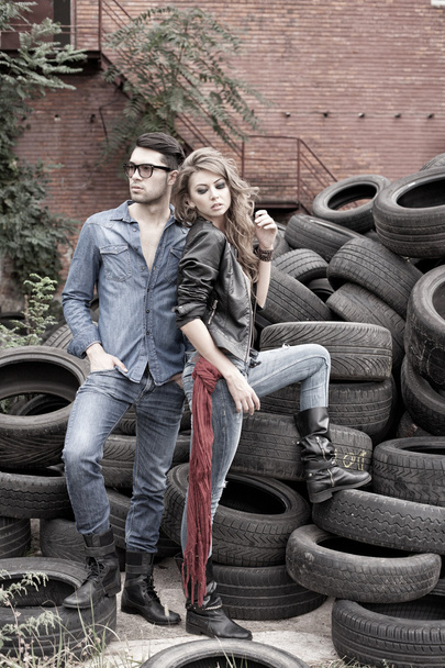 Sexy and fashionable couple wearing jeans, shoot in a grungy location - landscape orientation with copy-space - Photo, Image