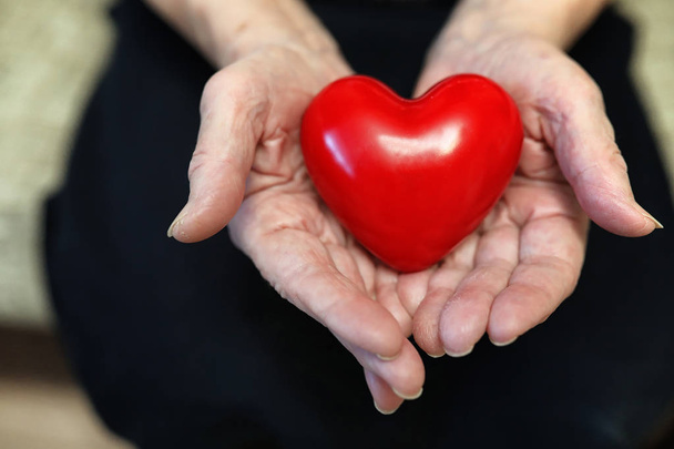 yaşlı kadın holding kalp - Fotoğraf, Görsel