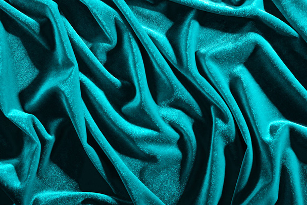 Cyaan kleur fluweel textiel voor achtergrond of textuur, gerimpeld en schaduwen - Foto, afbeelding