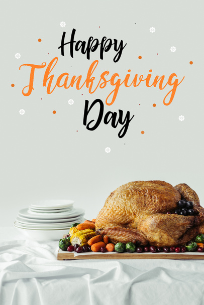 close up view of roasted turkey, cutlery and happy thanksgiving day lettering on grey background - Fotoğraf, Görsel