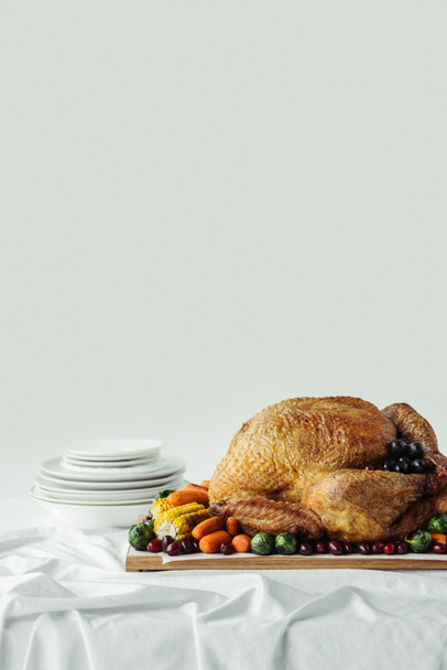 close up view of holiday dinner table set with roasted turkey and vegetables on grey background, thanksgiving holiday concept - Photo, Image