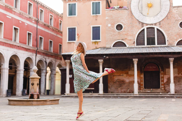 Una turista viajando por Italia. Chica joven con sombrero blanco en Venecia en la calle vieja
.  - Foto, imagen