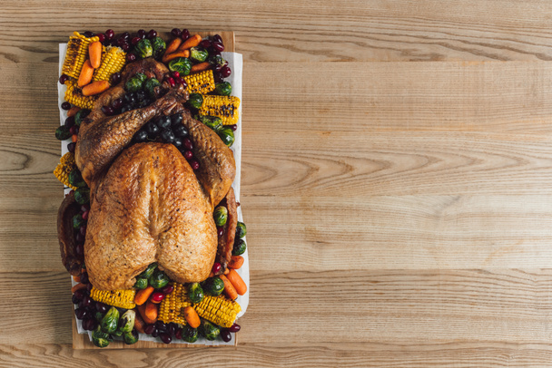 bovenaanzicht van geroosterde Turkije en groenten voor traditionele thanksgiving diner op houten tafelblad - Foto, afbeelding