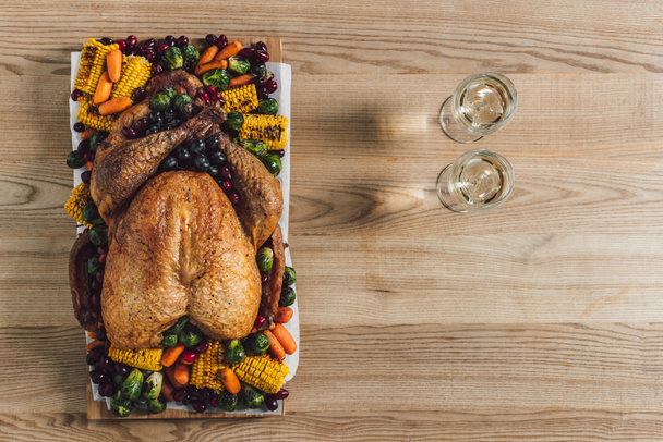 木製卓上に七面鳥のロースト、野菜、伝統的な感謝祭のディナーのためのワインのグラスのトップ ビュー - 写真・画像