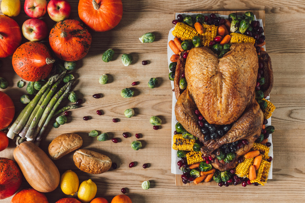 top view of roasted turkey and vegetables for thanksgiving traditional dinner on wooden tabletop - 写真・画像