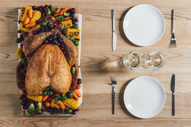 tumbado plano con pavo asado, verduras y copas de vino para la cena de Acción de Gracias en la mesa
 - Foto, Imagen