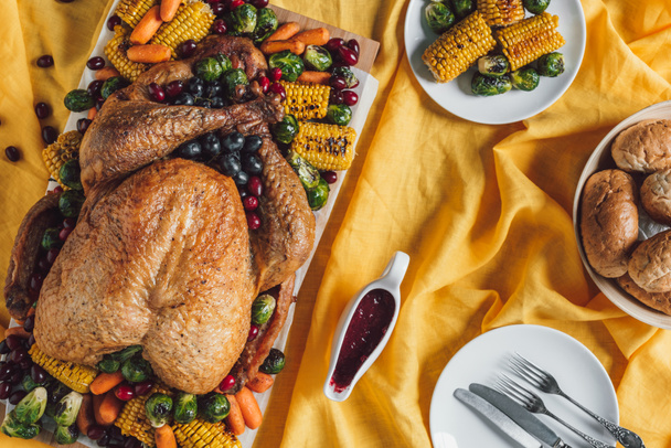 flat lay with roasted turkey, vegetables and sauce for thanksgiving holiday dinner on tabletop - 写真・画像