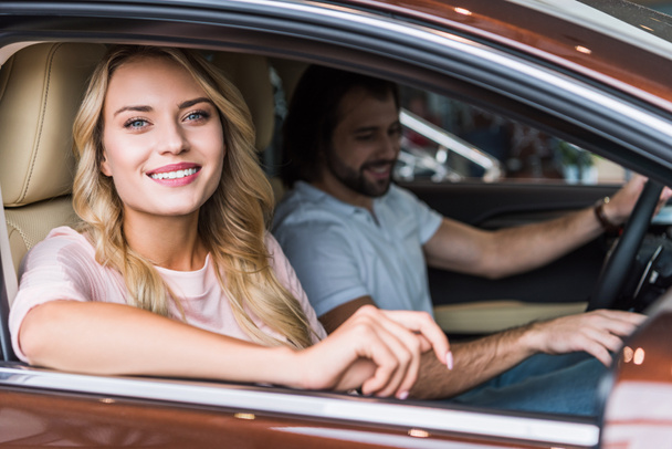 portrait of happy couple in new car at dealership salon - Foto, immagini