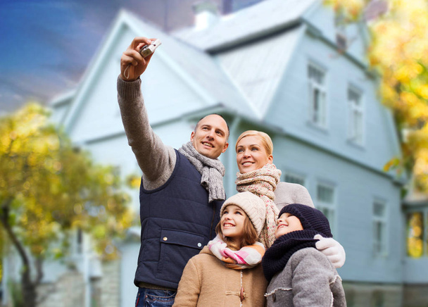 family takes autumn selfie by camera over house - Valokuva, kuva