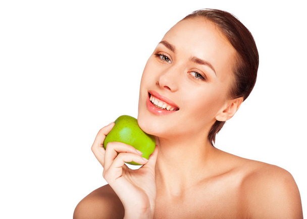 Portrait of young woman with natural makeup posing with green apple on white background  - Photo, Image
