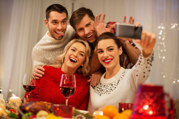 friends taking selfie at christmas dinner - Foto, afbeelding