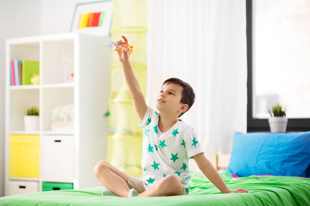 happy little boy playing with airplane toy at home - Φωτογραφία, εικόνα