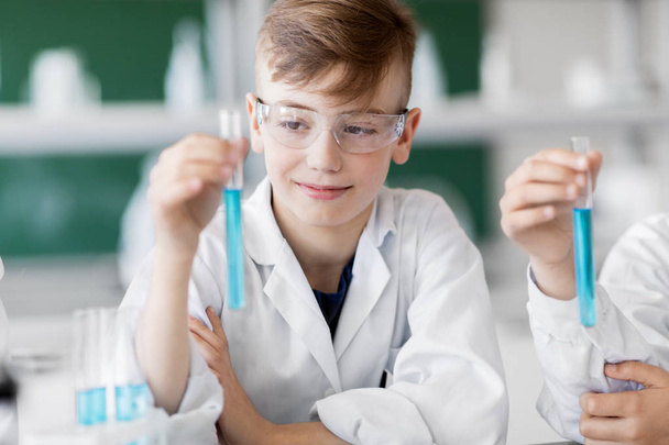 boy with test tube studying chemistry at school - Фото, изображение