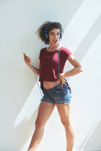 Funny young woman in headphones listening to music - Foto, Imagem