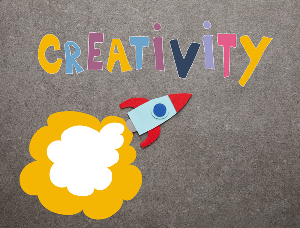 kleurrijke handgemaakte raket op grijze achtergrond met "creativiteit" inspiratie - Foto, afbeelding