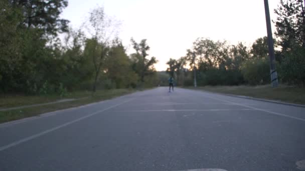 Karışık yarış hipster adam longboarder yarış yavaş çekimde bir şehir parkı - Video, Çekim
