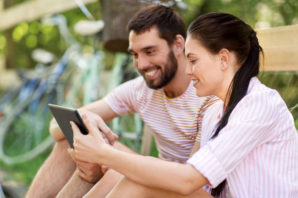 couple with tablet pc and bicycles at summer park - Foto, Imagen