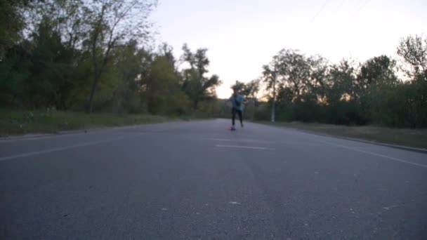 Carrera mixta hipster hombre longboarder carreras en el parque público de la ciudad en cámara lenta
 - Imágenes, Vídeo
