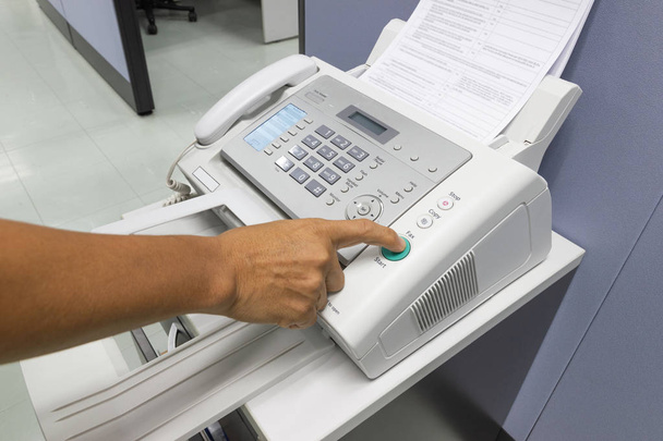 Hand man stanno utilizzando un fax in ufficio Business concept
  - Foto, immagini