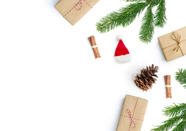 frohe weihnachtliche Layout-Komposition, Draufsicht mit Weihnachtsgeschenken, Zimtstangen, Tannenzweigen und Tannenzapfen auf weißem Hintergrund. - Foto, Bild