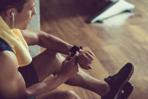 Jovem atleta confiante monitorando relógio de pulso no ginásio
 - Foto, Imagem