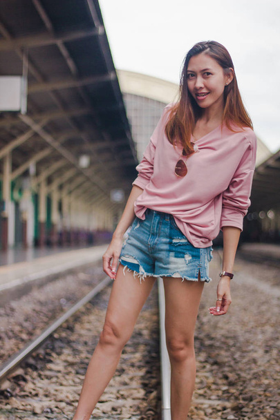Woman standing on a railroad track - Fotó, kép