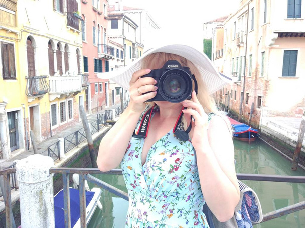 Mujer joven en sombrero blanco tomando fotos de la ciudad antigua
 - Foto, Imagen