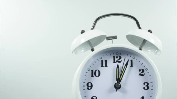 Despierte en la pausa del almuerzo. Mostrar reloj mostrando el horario a las 12.00 horas. en la cara grande del reloj analógico, en fondo blanco. - Metraje, vídeo