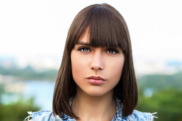 Portrait of young brunette girl on blurred nature background - Fotografie, Obrázek