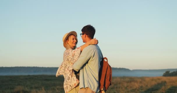 Portrait shot of the happy Caucasian girlfriend and boyfriend hugging and kissing in the beautiful field. - Felvétel, videó