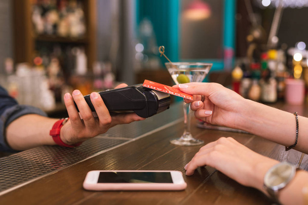 Young girl using credit card while paying in the bar - Foto, Bild