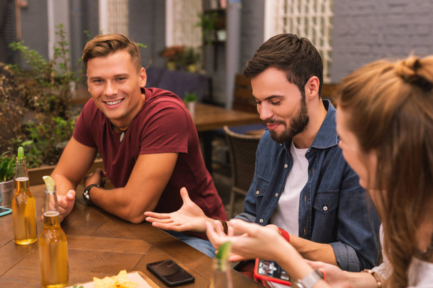 Emotional man using gestures while talking to friends in bar - Photo, Image