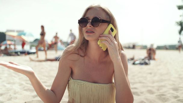 Ładna kobieta w bikini rozmowy na telefon na plaży. - Zdjęcie, obraz