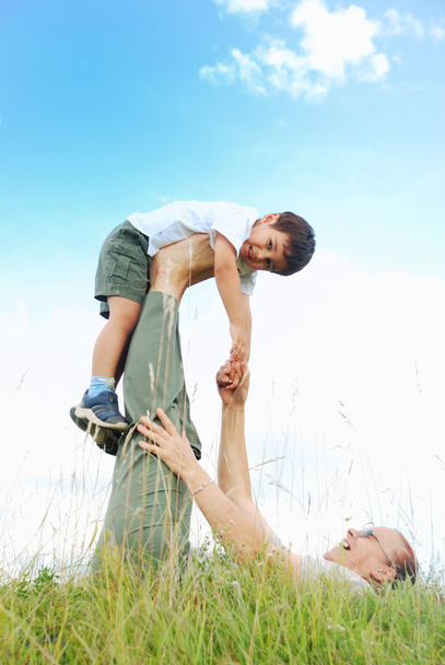 Happy kid in nature flying on grandmom's legs - Photo, Image