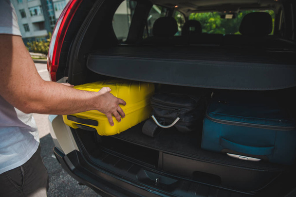 hands load bags in car trunk. car travel concept - Photo, Image
