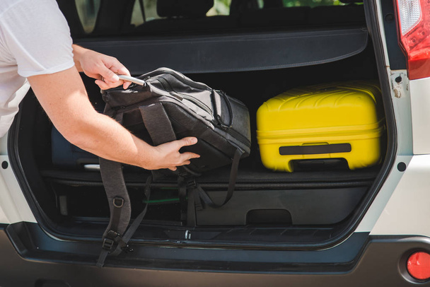 hands load bags in car trunk. car travel concept - Φωτογραφία, εικόνα