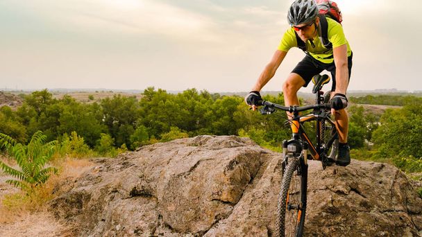 Rowerzysta, jazda na rowerze na jesienią skalistego szlak o zachodzie słońca. Sport ekstremalny i koncepcja rowery Enduro. - Zdjęcie, obraz
