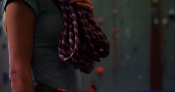 Female coach looking up at the artificial wall at bouldering gym 4k - Footage, Video