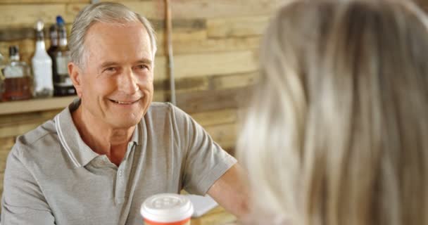 Smiling man at cafe counter serving coffee to a woman 4k - Filmmaterial, Video