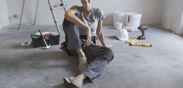 Woman sitting on the floor with tools, she is planning a home renovation - Foto, Bild