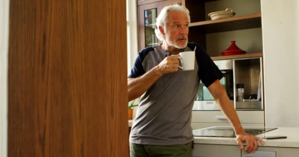 Senior man having coffee in kitchen at home 4k - Filmagem, Vídeo