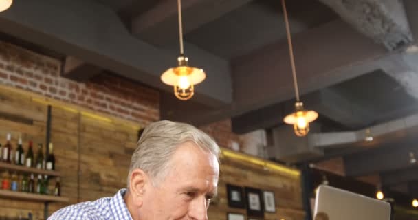 Close-up of senior man using laptop in the restaurant 4k - Video
