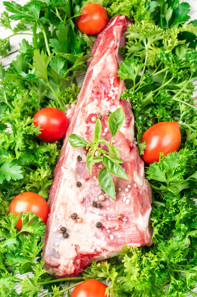 Trozo de carne de cerdo brisket costillas espátula sazonada con sal y pimienta y ramita de albahaca
 - Foto, imagen