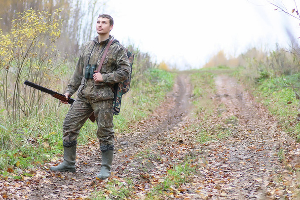 Mann in Tarnung und mit Schusswaffen im Waldgürtel auf Frühjahrsjagd - Foto, Bild